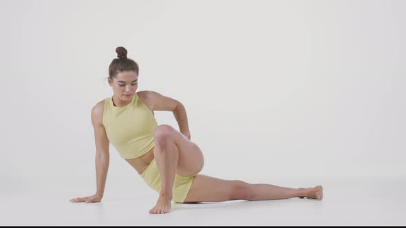 Young Sporty Flexible Lady Doing Downward Dog and Matsyendrasana Poses Stretching Her Body White