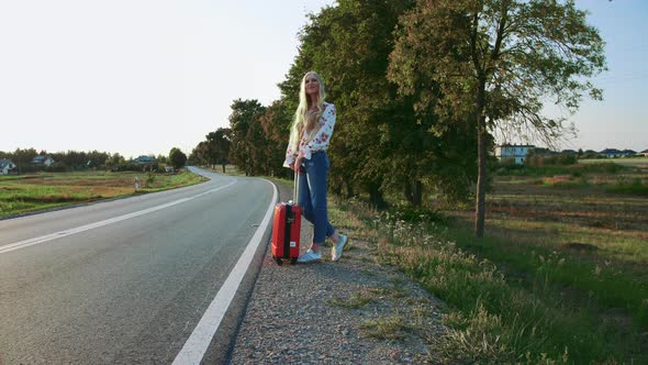 Traveler Woman Hitchhiking on a Sunny Road and Walking