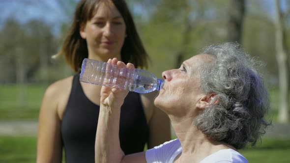 Cheerful Senior Woman Drinking Water Outdoor