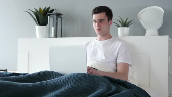 Reaction of Loss By Sad Man Using Laptop in Bed