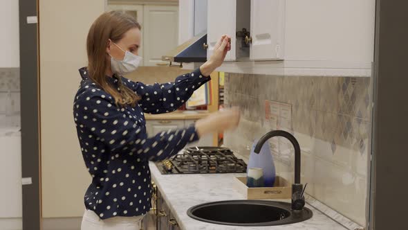 Woman in a Protective Mask Chooses Kitchen Furniture in a Store