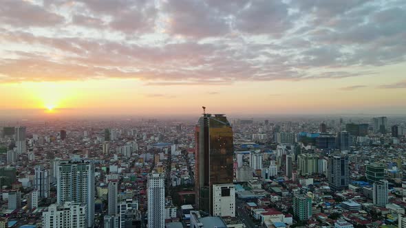 Aerial wide shot of high-rise during building phase and natural golden sunset in backgroud.Phnom Pen