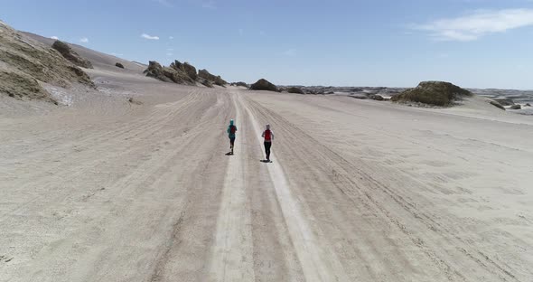 Two women trail runners cross country running in the desert