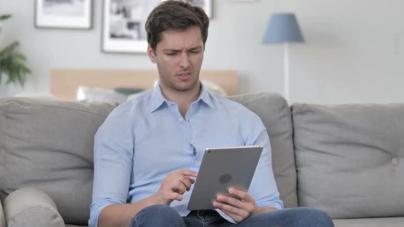 Handsome Young Man in Shock By Loss While Using Tablet