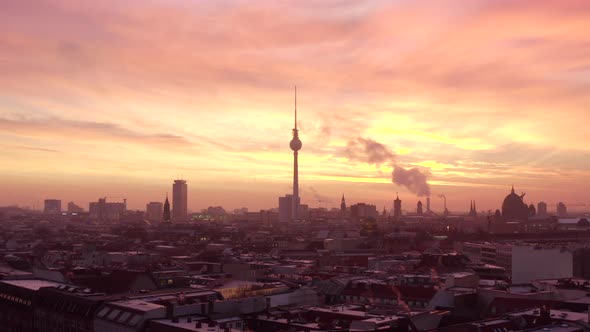 Beautiful View of Berlin TV Tower Alexanderplatz with with Smoke on Rooftops at Sunset or Sunrise