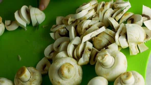 Close-up top view of a chef cuts mushrooms champignons.