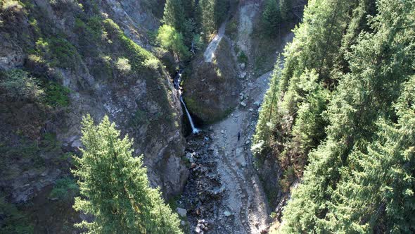 A Mountain Waterfall in a Rocky Gorge with Forest