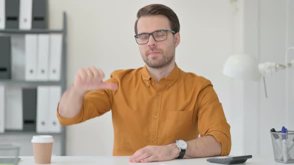 Young Man Showing Thumbs Down Sign 