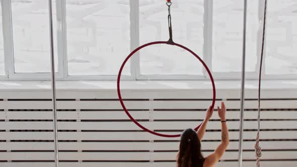 Gymnastic Training  Young Woman Climbs Onto the Acrobatic Ring