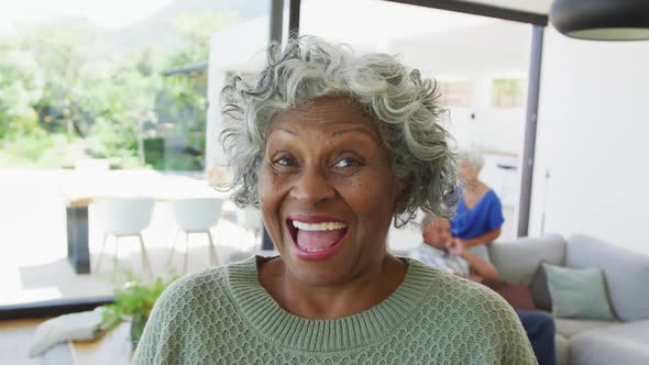 Portrait of happy senior african american woman with other seniors at retirement home