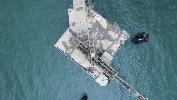 Revealing drone view of an industrial structure protruding from the ocean located on an environmenta