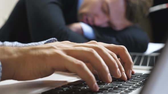 Close Up to Arms of Young Manager Typing Text on Laptop Keyboard at Office