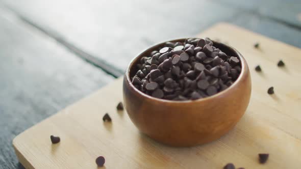 Video of close up of bowl with organic chocolate chip on wooden background