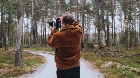 A Young Blond Male Photographer Takes Pictures of Nature