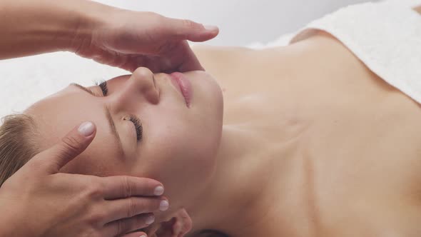 Young, healthy and beautiful woman gets massage therapy in the spa salon.