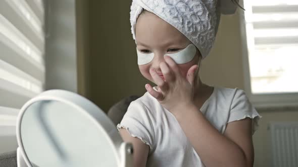 Girl 67 Years Old with a Serious Look Applies Patches Under the Eyes in Front of the Mirror