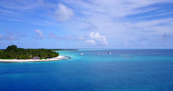 Beautiful above travel shot of a paradise sunny white sand beach and blue ocean background in 4K