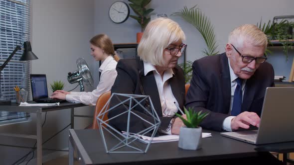 Elderly Man Boss with Woman Colleague Working in Office Developing New Project on Laptop Team Work