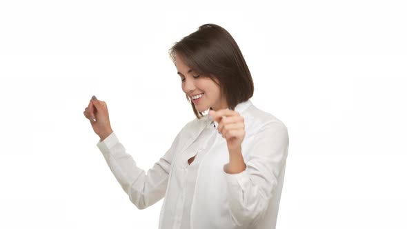 Horizontal Portrait of Cheerful Businesswoman in Elegant Shirt Dancing Being Happy Singing Raising