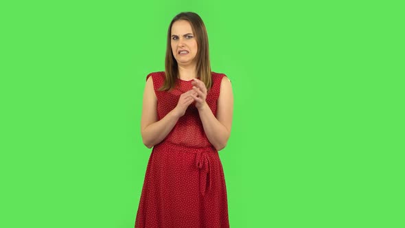Tender Girl in Red Dress Is Clapping Her Hands with Dissatisfaction. Green Screen