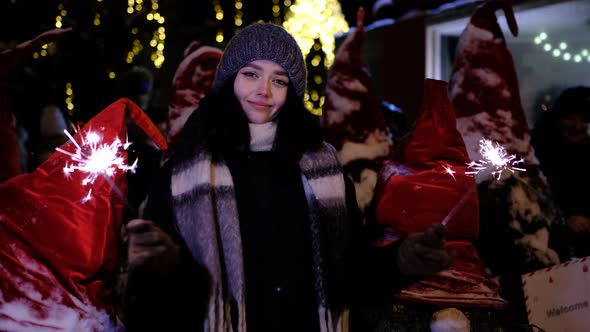 Woman, girl on Christmas dancing with bengal sparklers fireworks Happy New Year celebration merry 