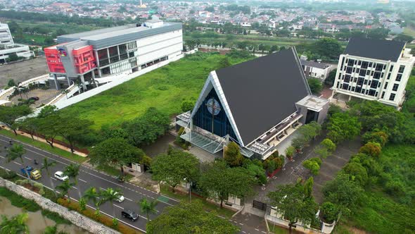 Aerial view of tracks vehicle on urban city street in Indonesia. Fly by church