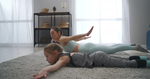 Home Fitness Training of Sporty Family Mother and Daughter Are Training Together in Living Room