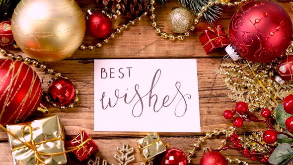 BEST WISHES card with Christmas decorations around on wooden table zoom in