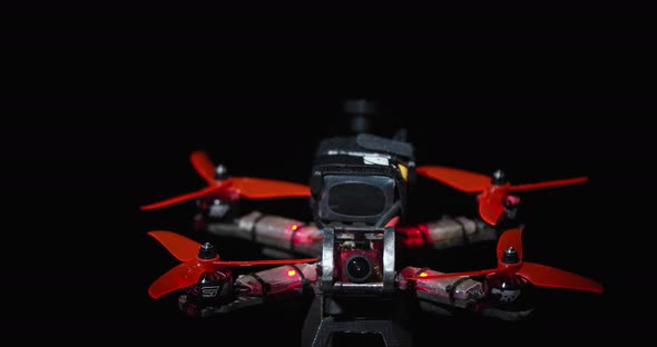 Bright Red Blades of an FPV Drone Start Spinning Black Background