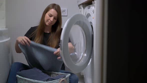 Woman Opens Door of Washing Machine Puts in Dirty Clothes and Takes Out Clothes