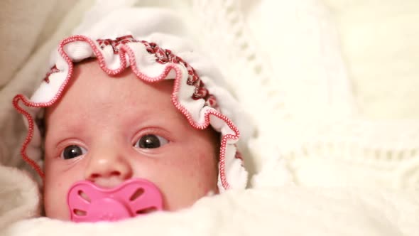 The Newborn Baby is Lying in the Crib She Has Big Green Eyes