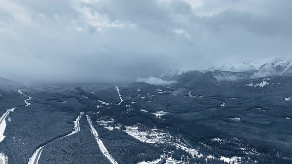 Bird's eye view camera captures forest valley between the mountains in Kananaskis, Alberta, Canada