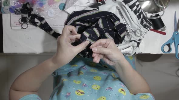 Top View of Woman's Hands Sewing a Button