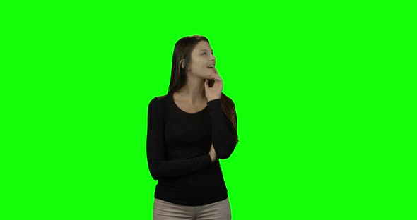 Smiling woman looking around against green screen