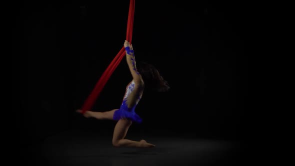 Female Aerial Gymnast Performing on a Red Silk in a Black Background. Exciting Acrobatic Show 060