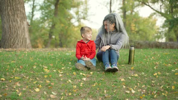 Mom with Her Son in the Park in Autumn