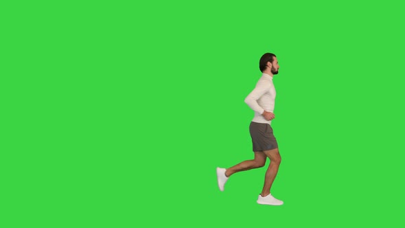 Healthy Looking Young Man Jogging on a Green Screen Chroma Key