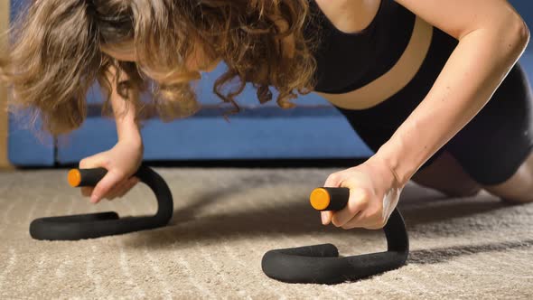 Woman Does Pushups Leaning on Special Stands on Floor