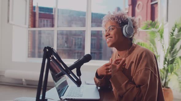 Successful African American Woman Broadcasts Live Using Laptop and Microphone