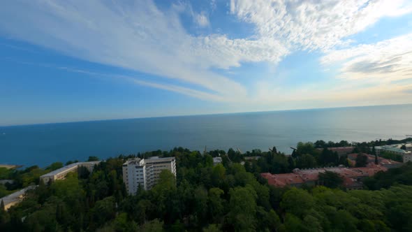 Aerial Panning Fpv Shot Touristic City at Seashore with High Trees and Modern Houses Surrounded By