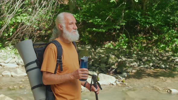 Portrait of an Elderly Man Tourist with a Reusable Water Bottle While Traveling