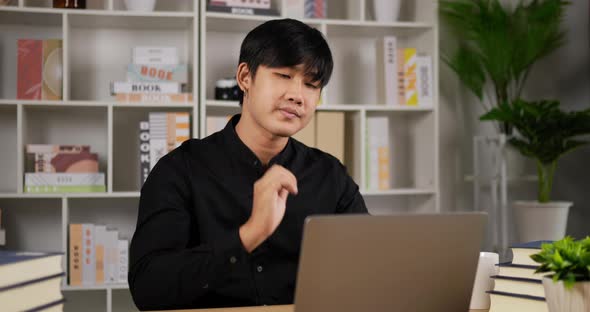 Businessman working on laptop and stretching