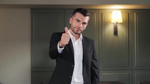 Man Businessman Looking at Camera Shows Like Puts Thumb Up Ok Sign