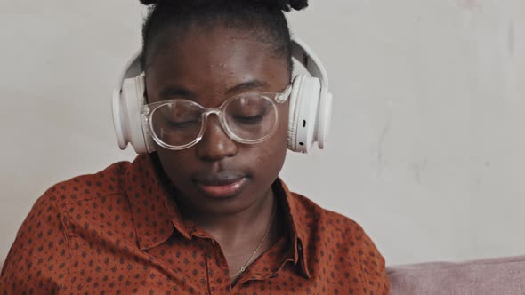 African American Woman in Headphones Watching Online Lesson