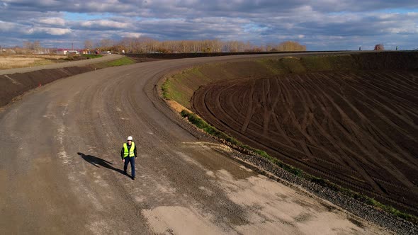 Chief in a White Helmet, Goes and Inspects the Construction of the Road. Aerial Survey