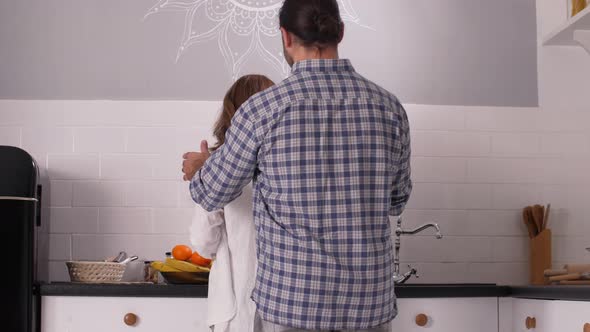 Happy Couple Expecting Baby Chatting in Kitchen