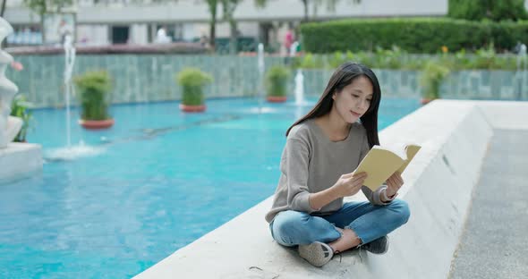 Woman read on the book and sit outside