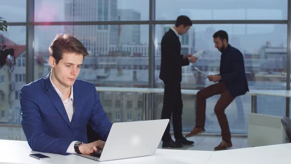 Business, People, Paperwork and Technology Concept - Busy Businessman with Laptop Computer