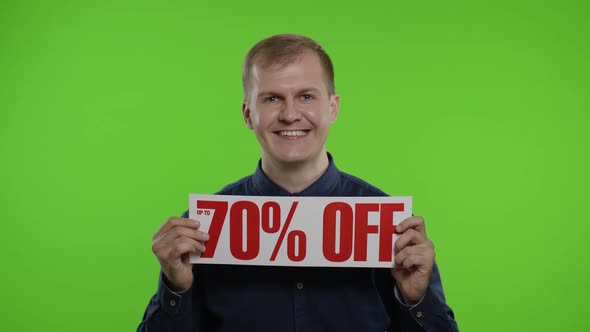 Cheerful Blonde Guy Showing Sale Word Advertisement. Online Shopping with Low Prices on Black Friday