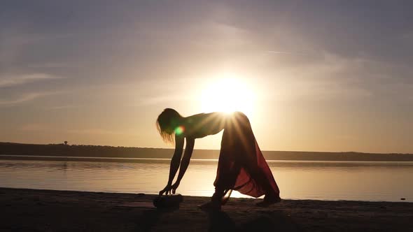 Young Woman Doing Yoga Exercise  Opening Her Yoga Mat on Near Sea or Ocean